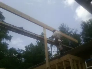 Carpenter setting a ridge beam over a new addition frame — Ice Dam Removal by Roofing Brothers in Mokena