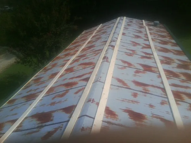 Rusted metal roof panels with new wood purlins before replacement — Storm Damage Roof Repair in Mokena by Roofing Brothers