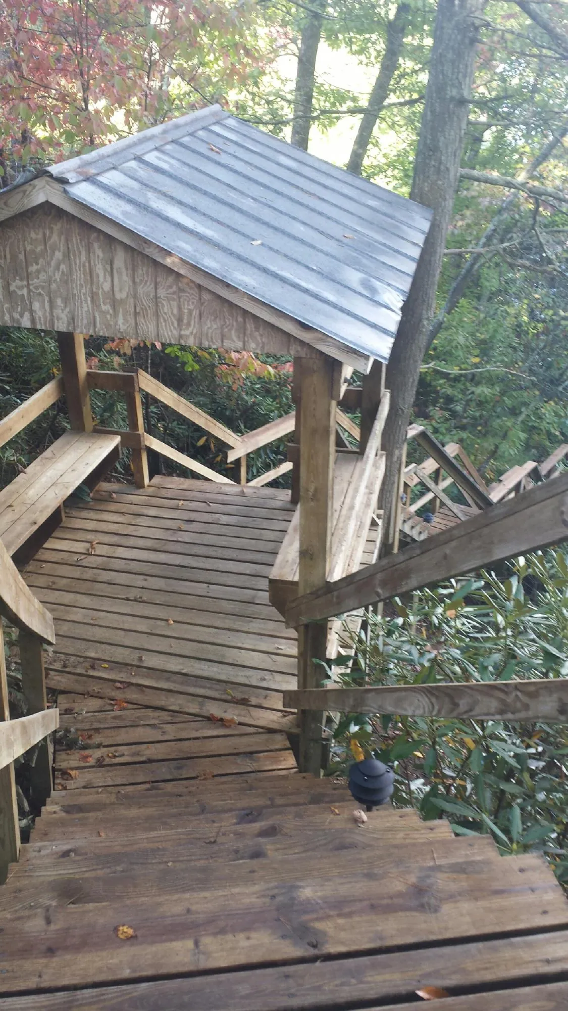Metal roofed shelter over wooden steps on a wooded walkway — Skylight Repair & Installation work by our crew in Mokena