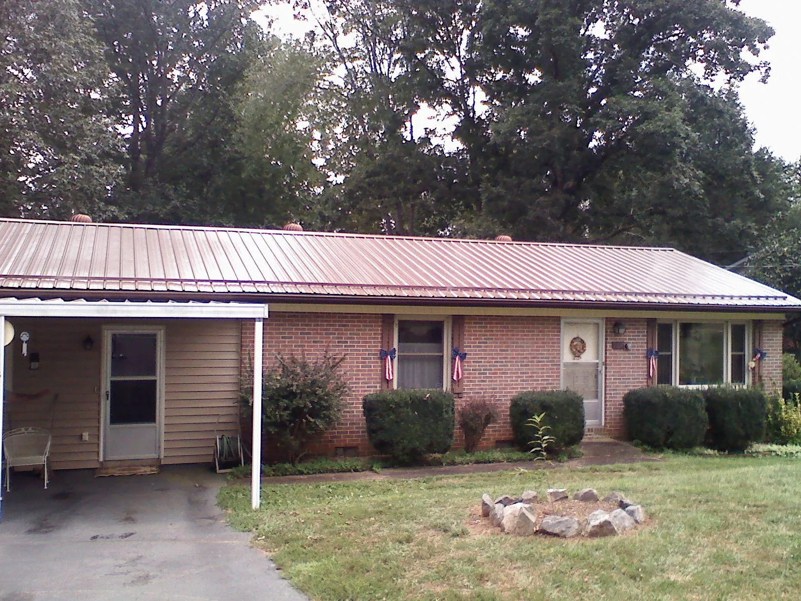 Bronze metal roof and carport on a brick ranch home — Roof Repair work by our crew in Mokena